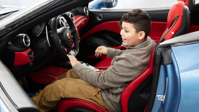 Tony Zazza sits and poses for photos in the luxerious Ferrari California