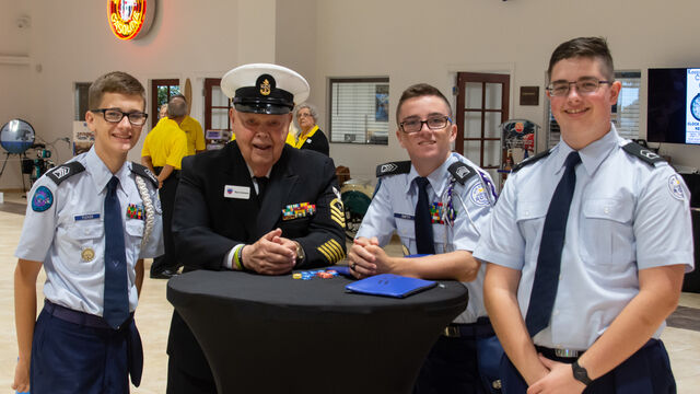 ROTC students and a veteran pose for photos at the Space Coast Honor Flight Event