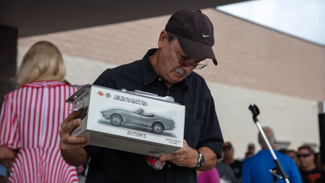 Holding up a Corvette scale model won at the raffle