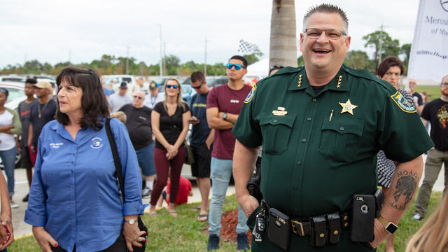 A police officer takes time out to take a photo with some of the attendees at Veteran's Day Open House